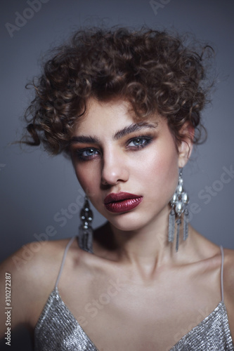Vintage style portrait of young beautiful girl with curly hair and smoky eye makeup, selective focus