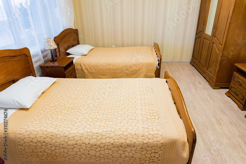 Interior of modern economy hotel room with twin beds in beige colour