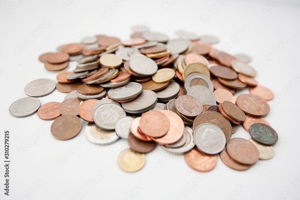 Close-up of large group of coins over white background Close-up of large group of coins over white background