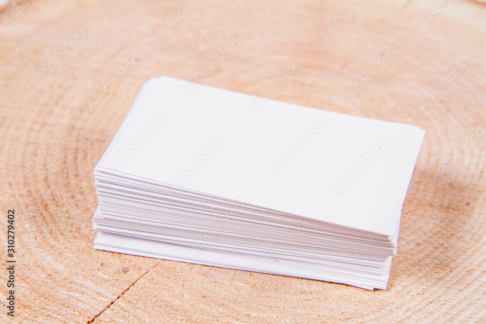 Fototapeta premium Stack of blank white business cards on a wooden background 