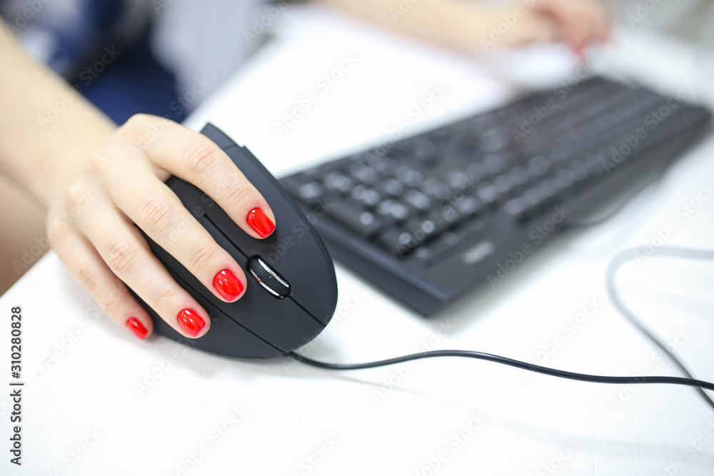 girl's hand uses a vertical ergonomic computer mouse joystick. girl's hand uses a vertical ergonomic computer mouse joystick.