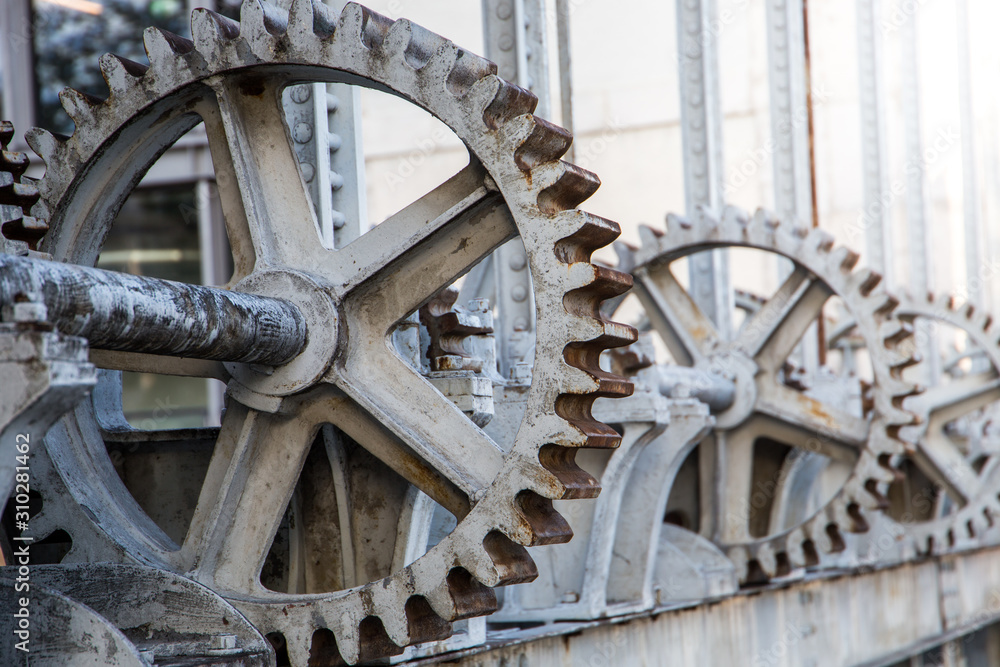 Giant steel gears in a floodgate (stop gate) used as a barrier to control the flow of water and prevent flooding.