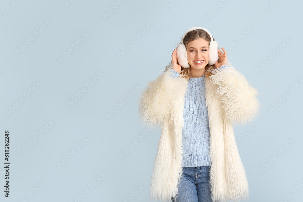 Happy young woman in winter clothes on color background Happy young woman in winter clothes on color background