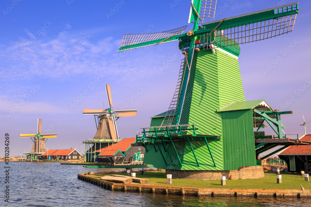 Vintage windmills on a sunny day in Zaanse Schans, Netherlands.