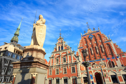 House of the Blackheads (Melngalvju nams) - historical building on Town Hall Square in Riga, Latvia, with St. Roland statue (1896.), under a blue sky with an interesting pattern of high cirrus clouds.