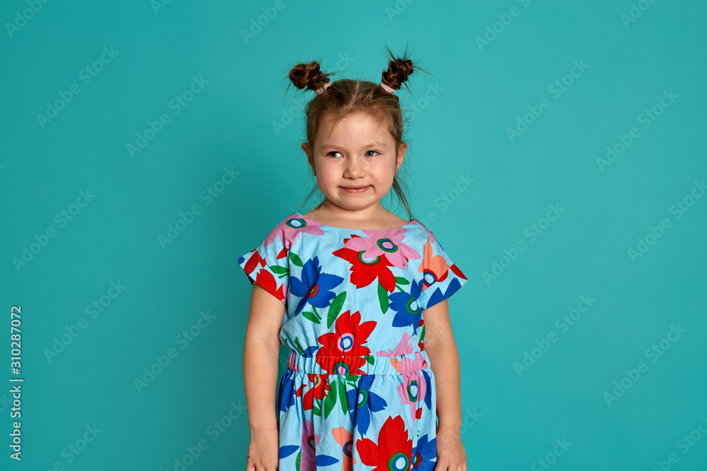 Little girl in on a blue background. Emotions of a child are anger, resentment, joy. Charming little girl smiling and showing her first lost milk tooth. Little girl in on a blue background. Emotions of a child are anger, resentment, joy. Charming little girl smiling and showing her first lost milk tooth.