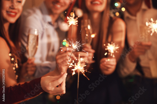 Photography Friends with sparklers celebrating New Year at party