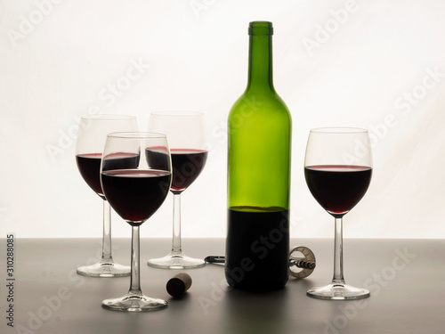 Close up of red wine glasses with a bottle of red wine