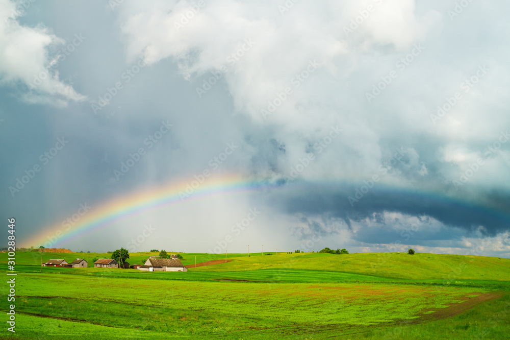 Rural landscape with rain clouds and a rainbow Rural landscape with rain clouds and a rainbow