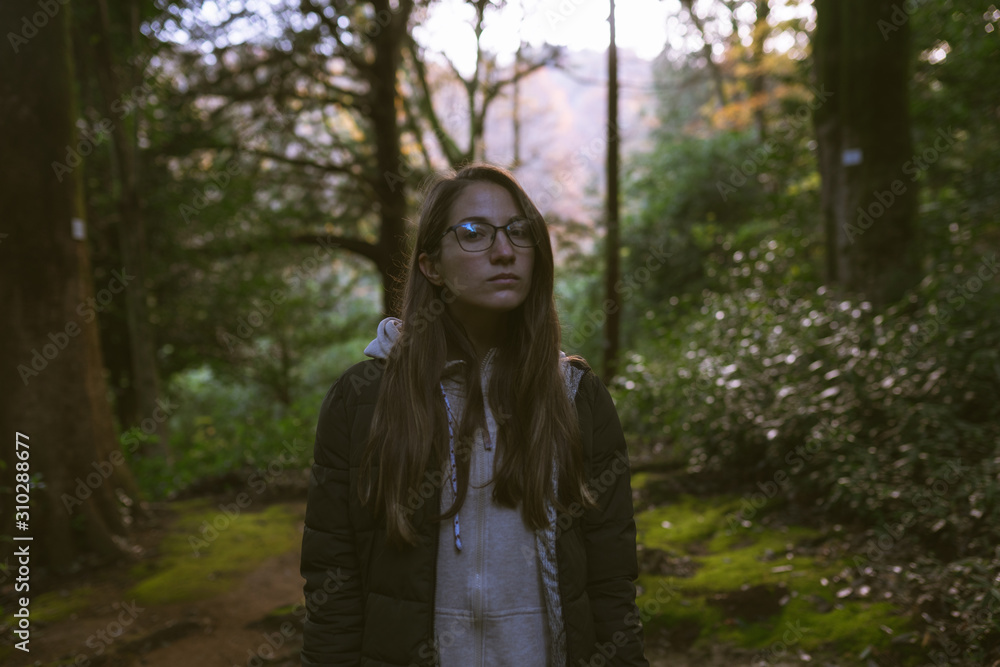 Beautiful girl in a mysterious forest as in a fairy tale. The mystical atmosphere of the forest. Old trees. Japanese garden. Atmospheric forest with green moss on the ground and moss on the branches Beautiful girl in a mysterious forest as in a fairy tale. The mystical atmosphere of the forest. Old trees. Japanese garden. Atmospheric forest with green moss on the ground and moss on the branches