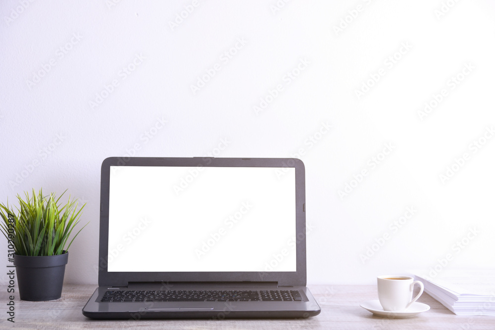 Modern white office desk table mockup ,work space with laptop computer with white screen for you text or image,green grass,cup of coffee and a stack of papers on white rock background. Modern white office desk table mockup ,work space with laptop computer with white screen for you text or image,green grass,cup of coffee and a stack of papers on white rock background.