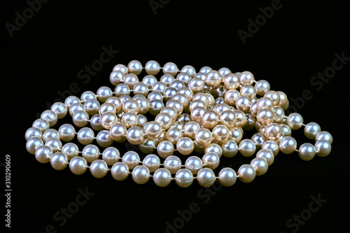 Fashionable necklace of genuine pearls on a black background isolated