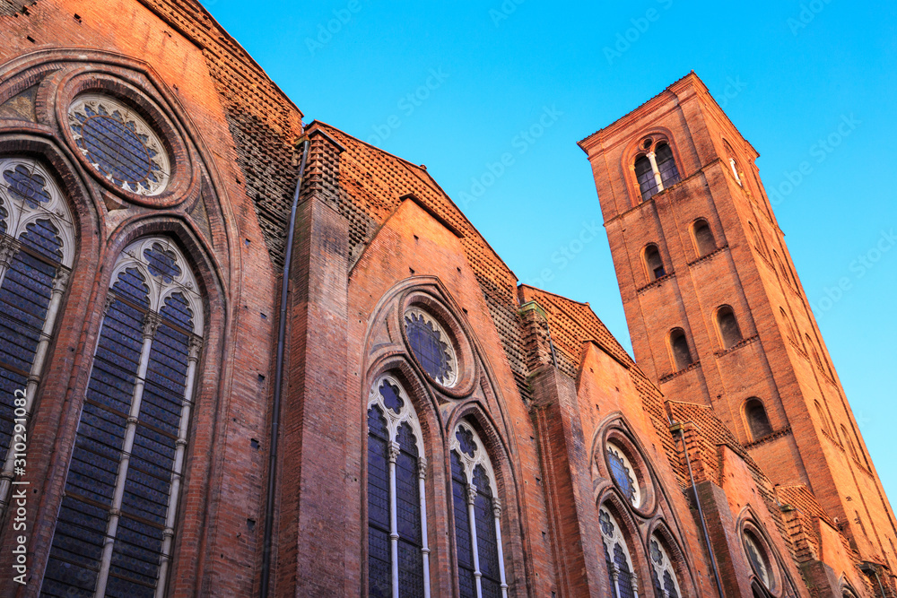 Φωτογραφία Basilica of San Petronio (Basilica Di San Petronio) in Bologna, Italy - rear part with the tower - at sunset, illuminated by the last rays of golden light, under clear blue sky
