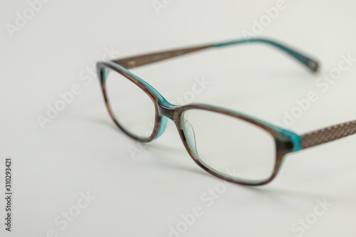 A pair of modern female reading glasses isolated in a studio shot black and turquoise colored frames prescribed from a profession optometrist with isolated white background 