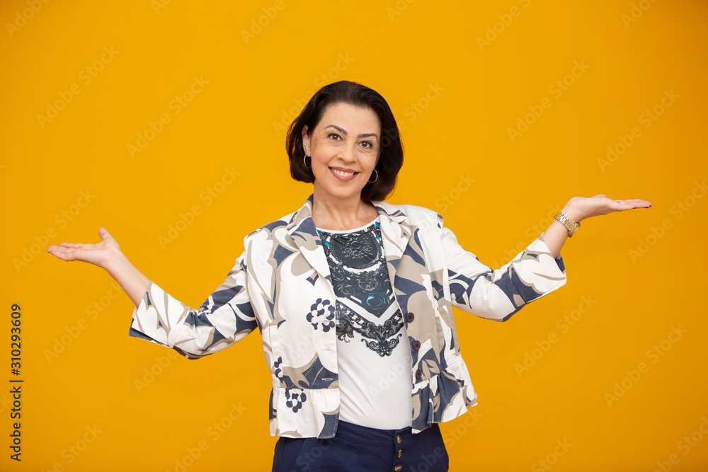 Beautiful middle age business woman smiling and looking at the camera pointing with hand to the side. Beautiful middle age business woman smiling and looking at the camera pointing with hand to the side.