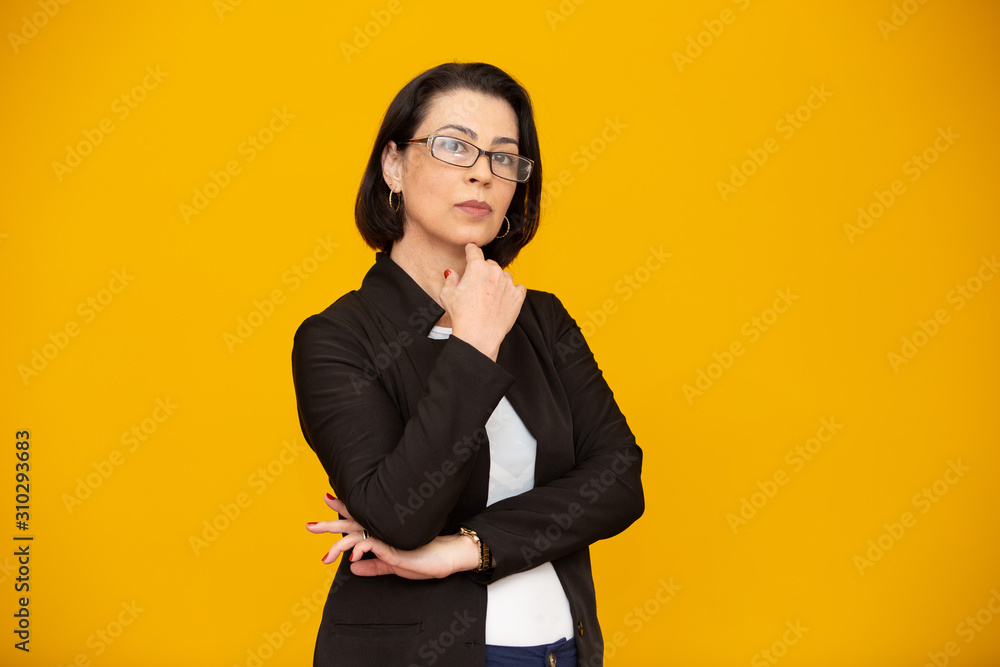Attractive middle aged woman with beautiful smile on yellow wall. Pretty older business woman, successful confidence with arms crossed. Attractive middle aged woman with beautiful smile on yellow wall. Pretty older business woman, successful confidence with arms crossed.