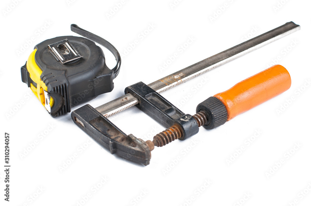 Carpentry clamp and measuring meter isolated on white background Carpentry clamp and measuring meter isolated on white background