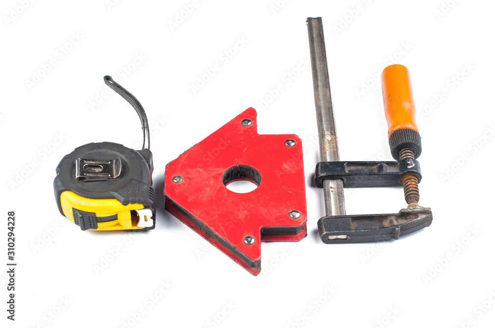 Fototapeta premium Carpentry clamp and measuring meter isolated on white background.Metal magnet