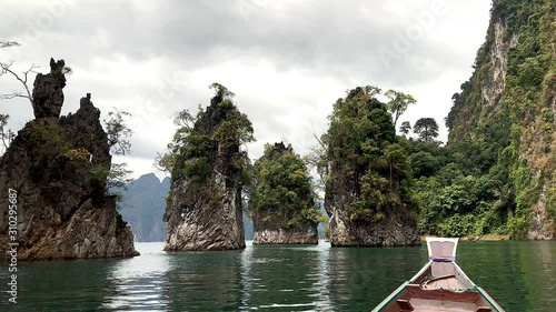 Tourism on boat exploring epic cliff in lake at Surat Thani,Thailand photo