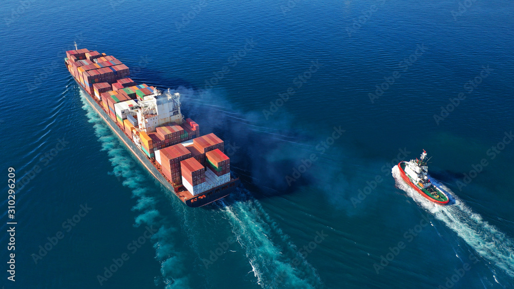 Aerial drone photo of industrial cargo container tanker ship carrier cruising the open ocean deep blue sea
