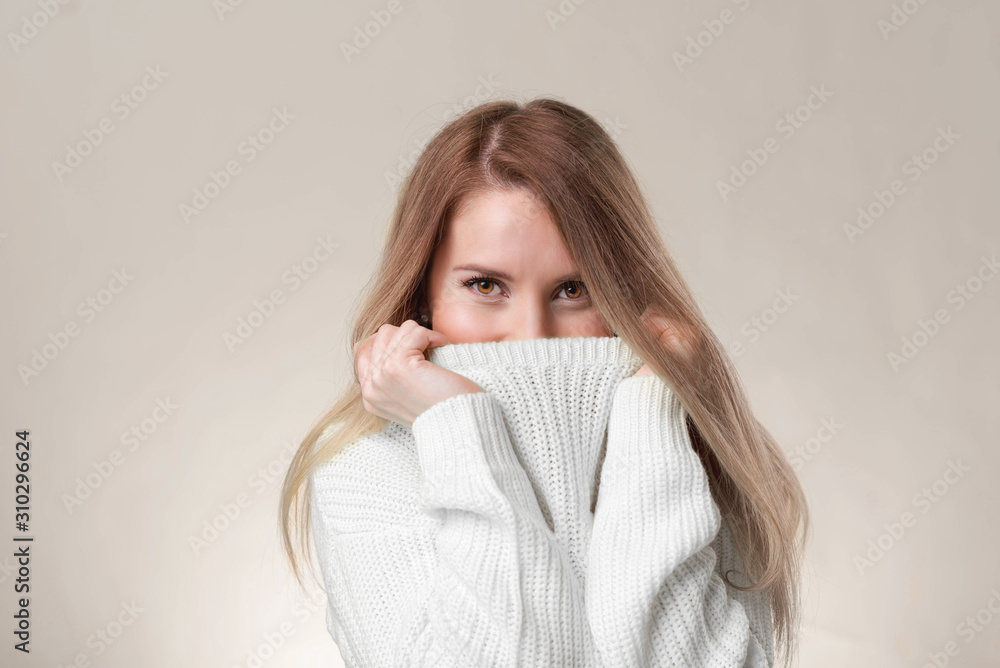 Close-up smiling pretty european, brown hair, pull sweater on face and smiling with eyes, playfully and flirty giggle, gazing camera, standing white background silly. Close-up smiling pretty european, brown hair, pull sweater on face and smiling with eyes, playfully and flirty giggle, gazing camera, standing white background silly.
