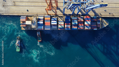 Aerial drone top down photo of industrial cargo container tanker ship carrier docked in commercial port terminal