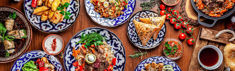 Traditional Uzbek oriental cuisine. Uzbek family table from different dishes for the New Year holiday. The background image is a top view.