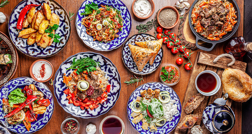 Traditional Uzbek oriental cuisine. Uzbek family table from different dishes for the New Year holiday. The background image is a top view. photo
