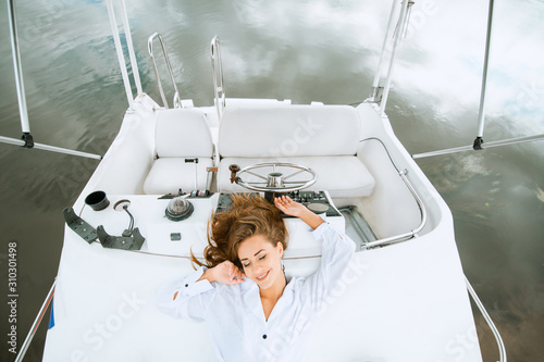 Pretty women lying on yacht deck and enjoying relaxing in sea travel photo