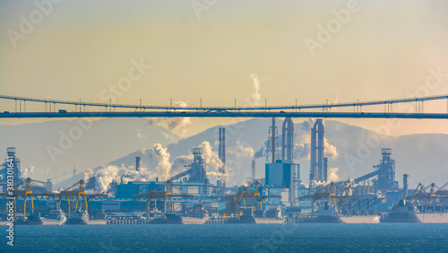 Sunrise autumn view to cargo carrier ships berthed near a Posco steel mill at the Port of Gwangyang, Jeonnam, Korea.