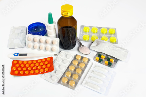 Flu and cold treatment - medicine in the form of tablets, ointments, aerosol and syrup, next to the medicine thermometer