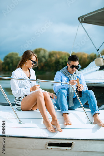 Man uncorking champagne and having party with girlfriend on vacation.