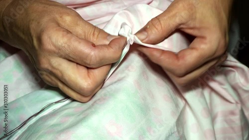 Wallpaper Mural an adult woman seamstress sews impales the fabric with a needle. Hands close up. grandma makes a smooth hand stitch. Making clothes and sewing colored bed linen at home or in a garment factory Torontodigital.ca