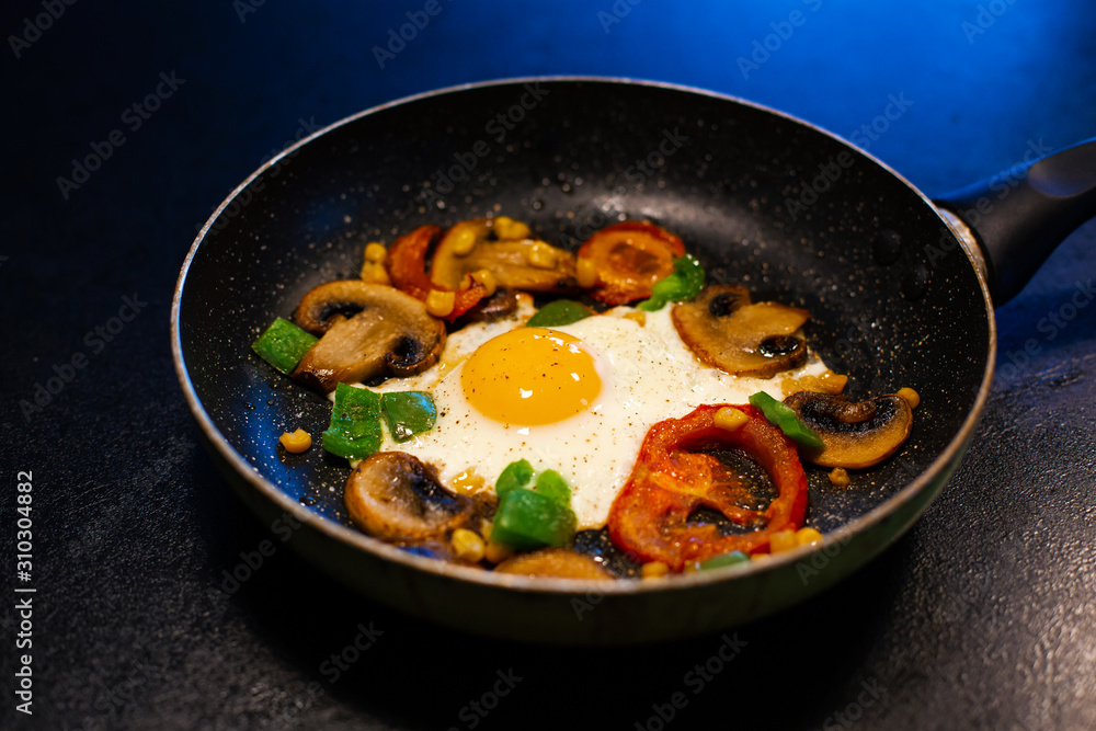 Freshly fried eggs with vegetables in a pan