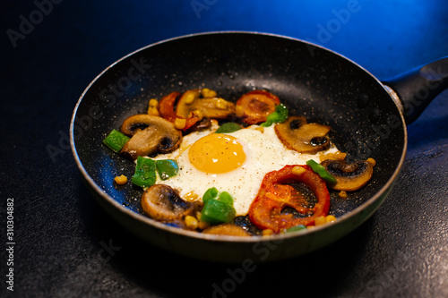 Freshly fried eggs with vegetables in a pan