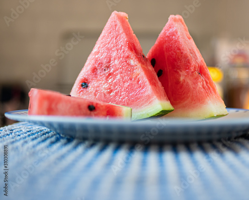 Slices of watermelon on a plate Flat view. Concept of freshness and summer time on the beach. Useful as a kitchen background.