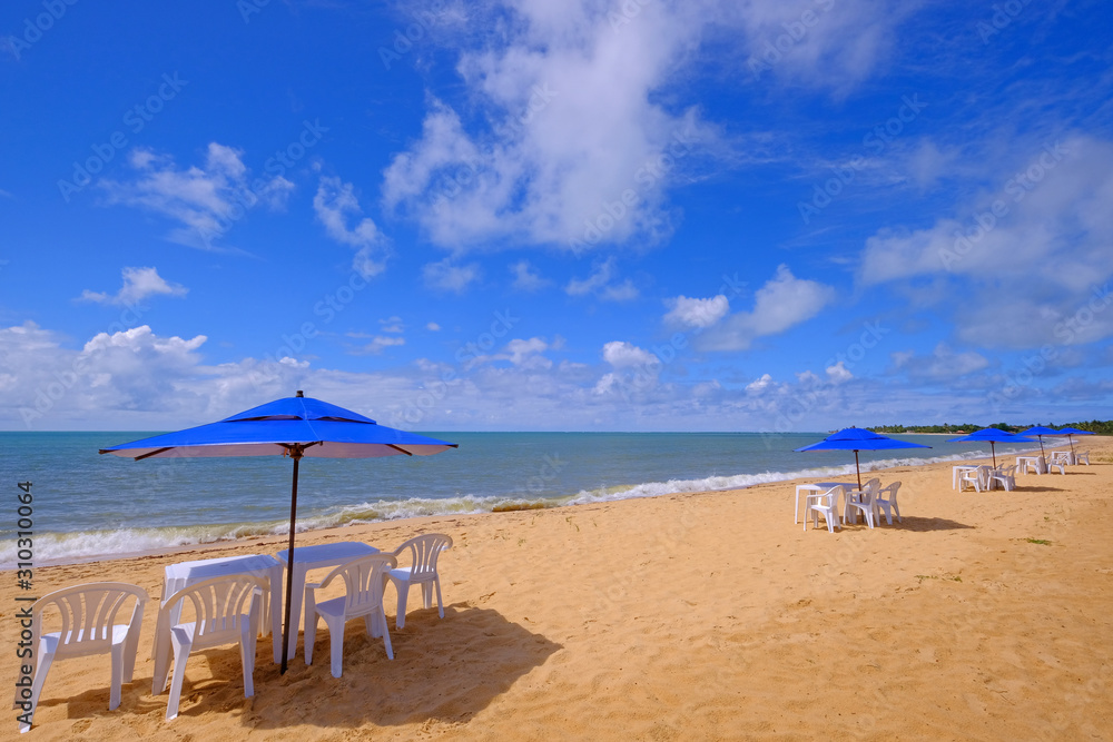 Fototapeta premium Beautiful sandy beach Praia Do Mutari Brava with beach chairs and umbrellas, Santa Cruz Cabralia, Coroa Vermelha, Porto Seguro, Bahia, Brazil