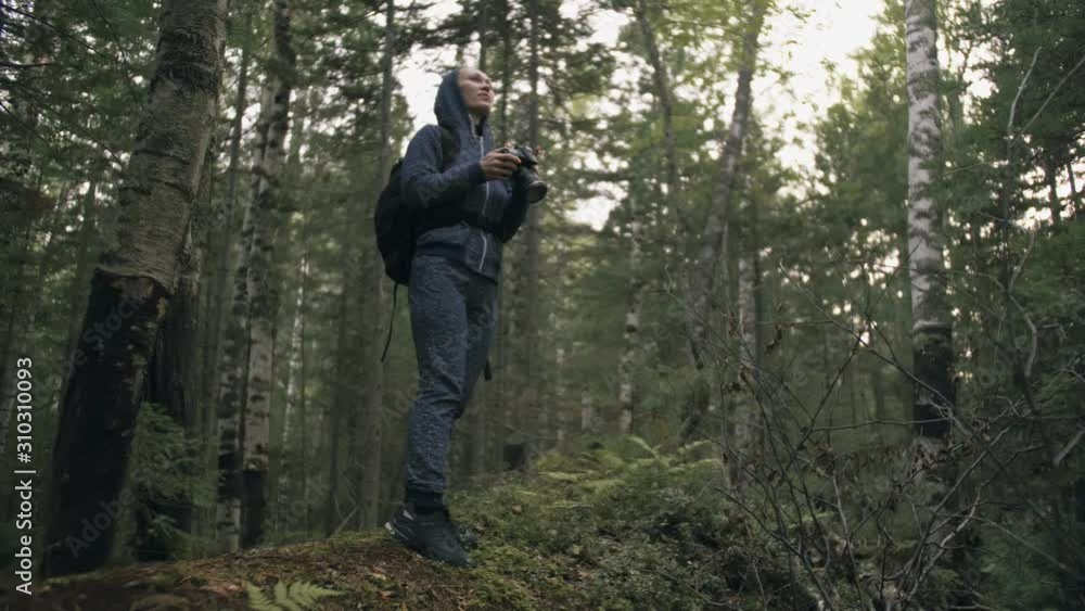 Traveler photographing scenic view in forest. One caucasian woman shooting nice magic look. Girl take photo video on dslr mirrorless camera. Professional photographer travel with backpack. Outdoor. Traveler photographing scenic view in forest. One caucasian woman shooting nice magic look. Girl take photo video on dslr mirrorless camera. Professional photographer travel with backpack. Outdoor.