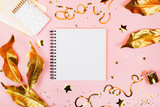 Note book on pink background with golden decorations. Festive concept in flat lay style