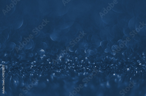 Classic Blue color. Color of the year 2020. Abstract festive bokeh background with shining defocus sparkles. Blurred glitters shimmering dust macro close up, copy space for text logo