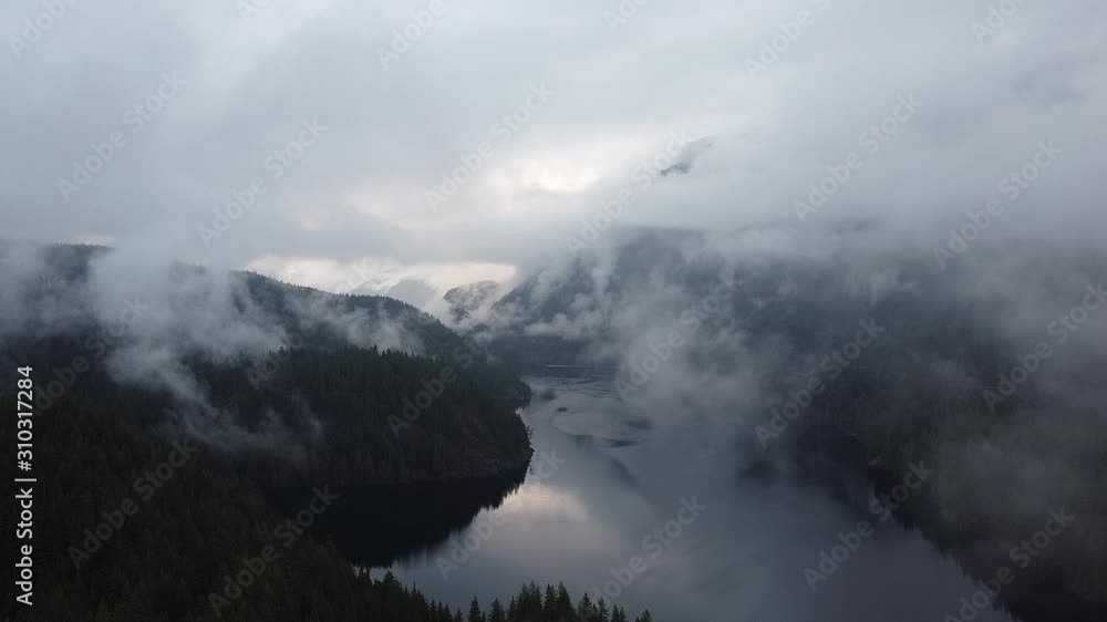 Establishing shot of the lake in between the mountains covered with forest Establishing shot of the lake in between the mountains covered with forest