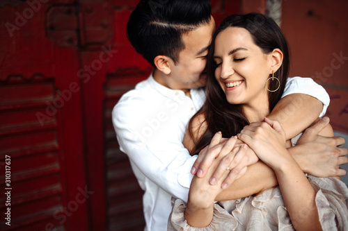 Charismatic guy and beautiful girl hug each other with love, outdoors