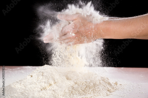chef s hand clapping with powder flour when kneading the dough