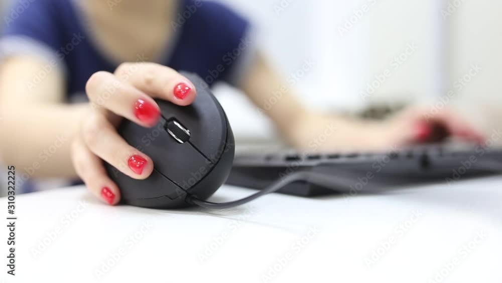 girl's hand uses a vertical ergonomic computer mouse joystick. girl's hand uses a vertical ergonomic computer mouse joystick.