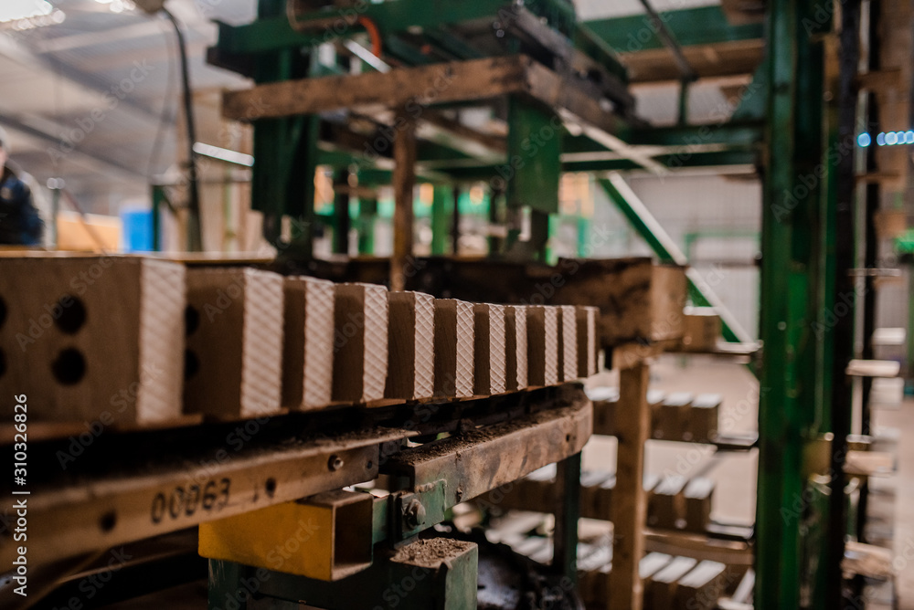 Plant for the production of bricks from clay. Plant for production building material with ready brick, construction industrial. Production of bricks on plant. Workflow, close-up. Many raw bricks Plant for the production of bricks from clay. Plant for production building material with ready brick, construction industrial. Production of bricks on plant. Workflow, close-up. Many raw bricks