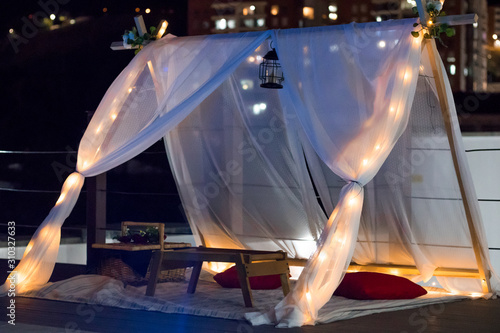 Romantic night picnic with cushions, lantern and basket