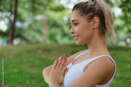 caucasian pretty woman having yoga in park
