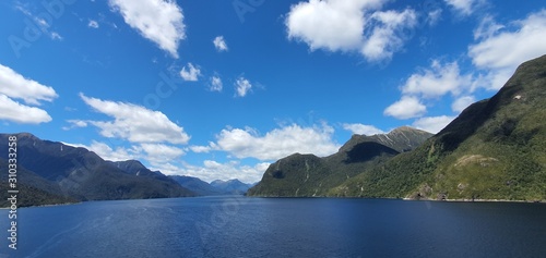 Doubtful Sound Fjord, Doubtful Sound / New Zealand - December 18, 2019: The Majestic Mountains and Waterfalls of the Doubtful Sound Fjord, New Zealand photo