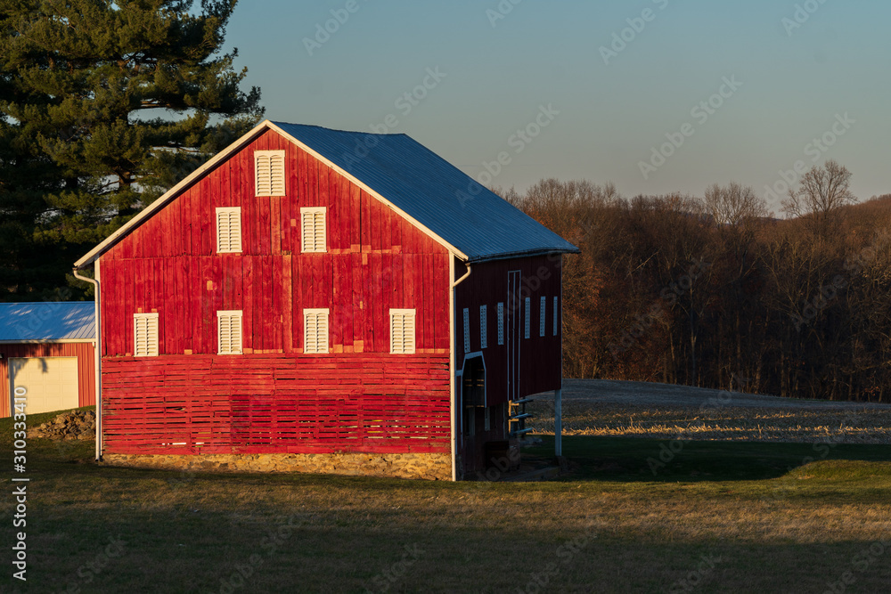 Obraz premium Red Barns and Farm Fields in a Winter Sunset