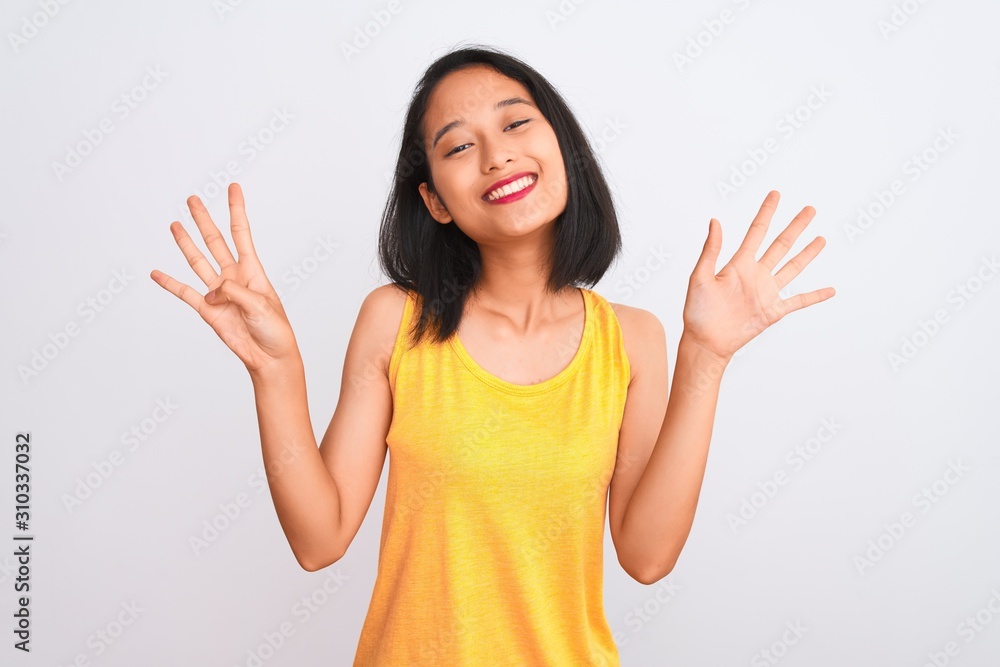 Young chinese woman wearing yellow casual t-shirt standing over isolated white background showing and pointing up with fingers number nine while smiling confident and happy. Young chinese woman wearing yellow casual t-shirt standing over isolated white background showing and pointing up with fingers number nine while smiling confident and happy.